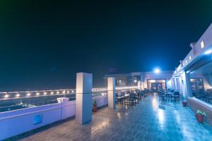 a rooftop bar with tables and chairs at night at Hotel Starlight in Nepālganj