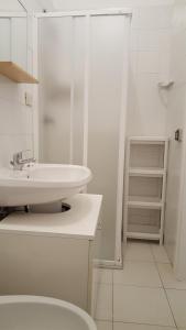 uma casa de banho branca com um lavatório e um WC em Casa Sofia em Vulcano