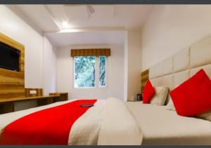 a bedroom with a large bed with red pillows at Hotel Awesome International in New Delhi