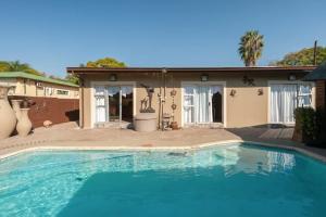 a swimming pool in front of a house at Genie's Nest 1 in Pretoria