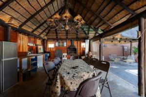 a kitchen and dining room with a table and a refrigerator at Genie's Nest 1 in Pretoria