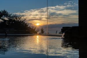 a pool of water with the sunset in the background at Kaiyutei in Kawazu +45 photos