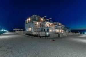 a large building on the beach at night at Apartment Amazing Island in Povljana