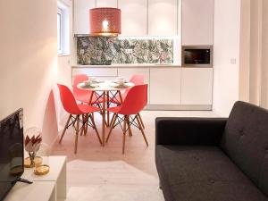 a living room with a table and red chairs at Casa Suyay Studio in Aveiro
