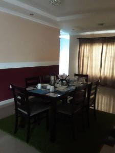 comedor con mesa, sillas y ventana en Ramatie Guest Palace, en Kasane