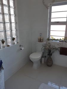 a white bathroom with a toilet and a window at THE VIEW in Port Alfred