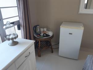 uma cozinha com uma pequena mesa e um frigorífico em THE VIEW em Port Alfred