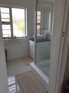 a white bathroom with a sink and a mirror at THE VIEW in Port Alfred