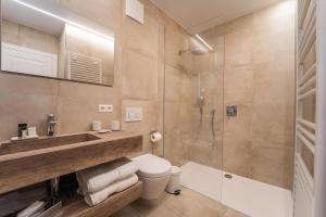 a bathroom with a shower and a toilet and a sink at Hotel Monvillage in Mondercange +37 photos