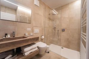 a bathroom with a shower and a toilet and a sink at Hotel Monvillage in Mondercange