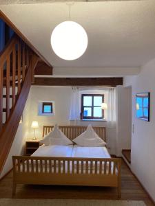1 dormitorio con 1 cama grande y una escalera en CALLM aka Zum goldenen Löwen - zu Nacht bei der Destillerie en Kallmünz