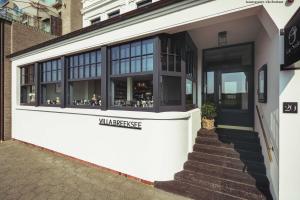 una tienda frente a un edificio con ventanas de cristal en Villa Breeksee, en Norderney