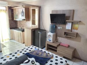 a small room with a kitchen with a bed and a television at Adhigana Property Kemang View in Pekayon Satu