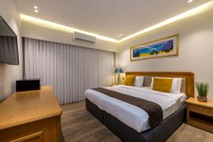 Melio Hotel Eilat في إيلات: غرفة في الفندق مع سرير ومكتب