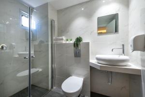 y baño con aseo, lavabo y ducha. en Melio Hotel Eilat, en Eilat