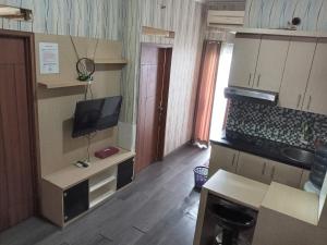 a small kitchen with a desk and a television at Adhigana Property Kemang View in Pekayon Satu