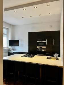 a kitchen with black cabinets and a large island at Apartament 52 City Center in Gdynia