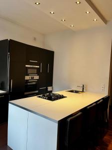 a kitchen with black cabinets and a white counter top at Apartament 52 City Center in Gdynia