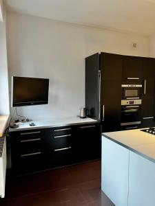 cocina con armarios negros y encimera blanca en Apartament 52 City Center, en Gdynia