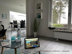 a living room with a table with a laptop on it at Ferienhaus Strandläufer in Langballig