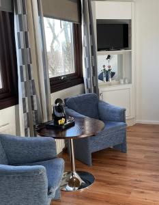 a living room with two chairs and a table and a tv at Eckerö Hotell & Restaurang in Eckerö