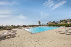 a swimming pool with two lounge chairs next to it at Estúdio vista mar Atlântico in Alvor