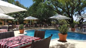 a pool with a table and chairs and umbrellas at Black Eagle Hotel & Spa in Roodepoort