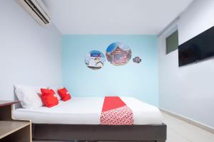 a bedroom with a bed with colorful pillows at Super OYO 90254 D Anugerah Hotel in Melaka