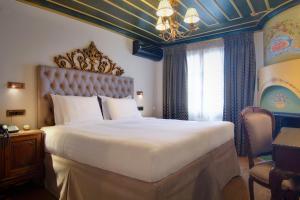 a bedroom with a large bed and a chandelier at ARCHONTARIKI Historic Boutique Hotel in Ioannina