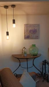 Cette chambre dispose d'une table avec un vase vert. dans l'établissement Casa Rural "Can Abres" Vilobi d`Onyar Girona, à Vilobí d'Onyar
