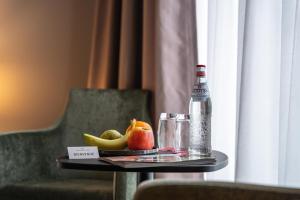 stół z butelką wody mineralnej i owocami w obiekcie Hotel Monvillage w mieście Mondercange