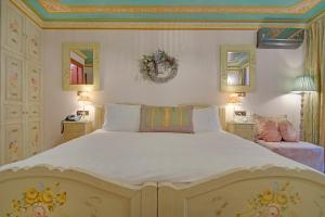 a bedroom with a large bed with white sheets at ARCHONTARIKI Historic Boutique Hotel in Ioannina