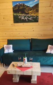 a living room with a couch and a table with wine glasses at DOMEK NA WIERCHU in Kluszkowce
