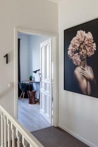 un couloir avec une photo d'une femme avec des fleurs sur le mur dans l'établissement B&B Josephine, à Grimbergen