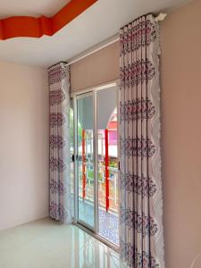 a room with a large window with curtains at Heaven Guesthouse in Pakse