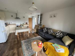 ein Wohnzimmer mit Sofa und Tisch in der Unterkunft Chestnut Cottage in East Bergholt + 12 Fotos