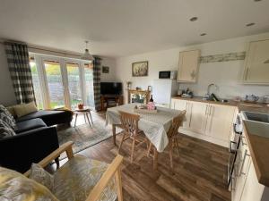 eine Küche und ein Wohnzimmer mit Tisch und Stühlen in der Unterkunft Chestnut Cottage in East Bergholt