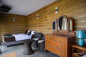 a bedroom with a bed and a dresser with a mirror at Pear Mount Farm House in Kodaikānāl