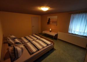 1 dormitorio con cama, mesa y ventana en Duschkas Ferienwohnung, en Am Frühlingsberg