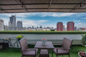 a table and chairs on a balcony with a view of a city at Centre Point Pratunam in Bangkok