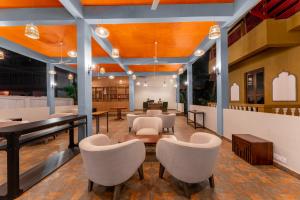 a lobby of a restaurant with chairs and a piano at juSTa Morjim Beach Resort Goa - 80 Steps from Morjim Beach in Morjim