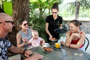 een groep mensen die rond een tafel zitten met een baby bij Hotel La Diga Altomincio in Valeggio sul Mincio