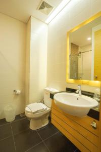 a bathroom with a toilet and a sink and a mirror at Life Hotel Stasiun Kota Surabaya in Gembong