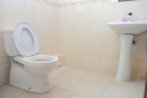 a bathroom with a toilet and a sink at sunset suswa apartment in Mombasa +9 photos