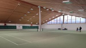 una pista de tenis con dos personas de pie en ella en Landpension Gschwantner, en Lengenfeld