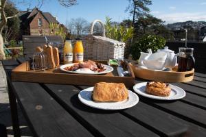 una mesa de madera con tres platos de comida. en Epchris House, en Ilfracombe