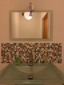 La salle de bains est pourvue d'un lavabo et d'un miroir. dans l'établissement Top floor duplex with private beach, à Duingt