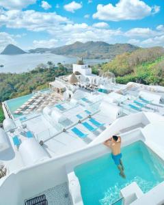a man standing on the edge of a swimming pool on a house at Loccal Collection Hotel Komodo in Labuan Bajo