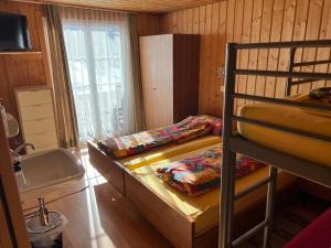 Zimmer mit 2 Etagenbetten und einem Waschbecken in der Unterkunft Berghotel Furggstalden in Saas-Almagell