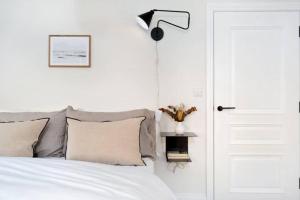 a bedroom with a bed with a lamp and a door at Exclusive Norman Road Apartment in St. Leonards